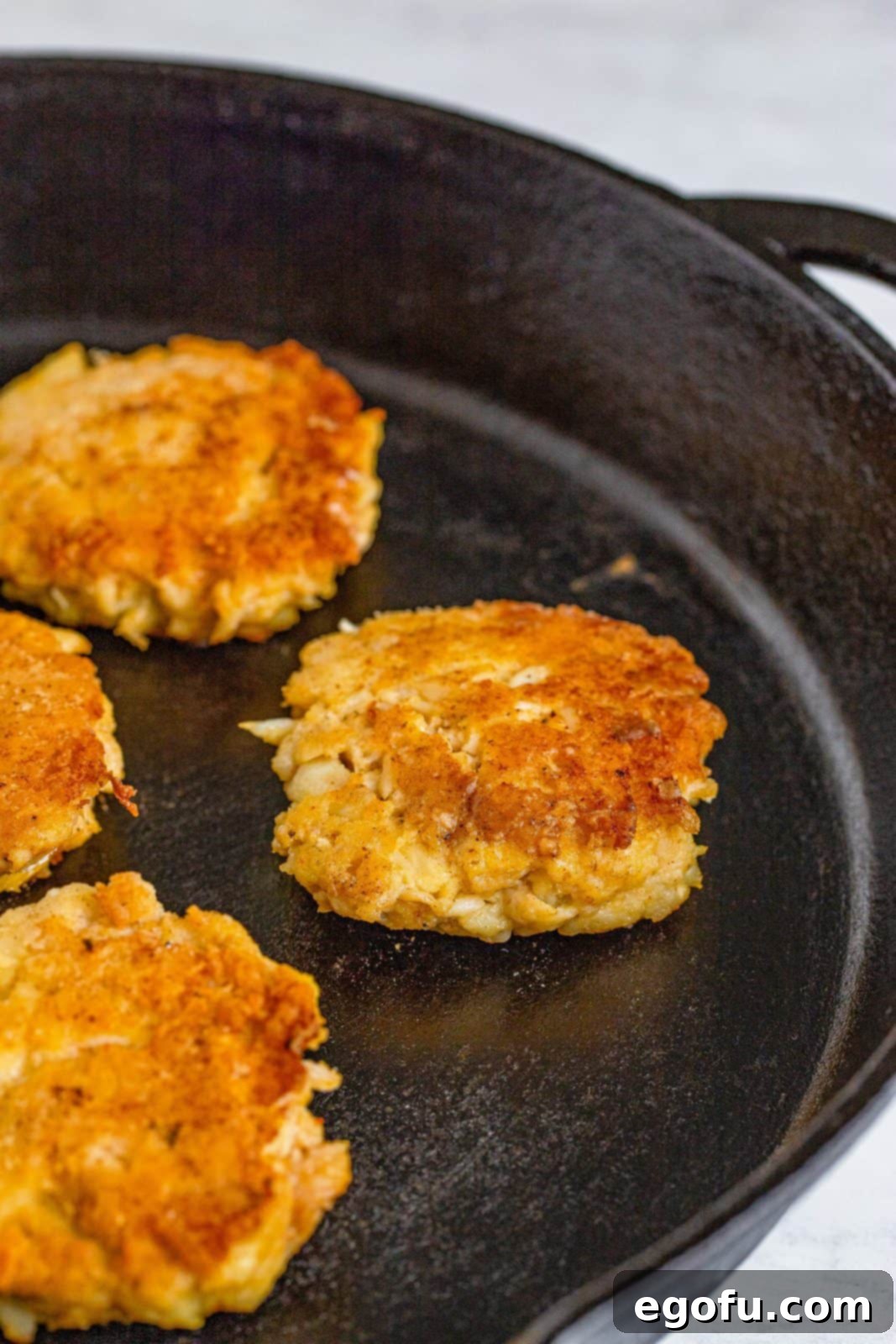 Lowcountry Crab Delights 8 Crab Cakes being browned in a skillet.