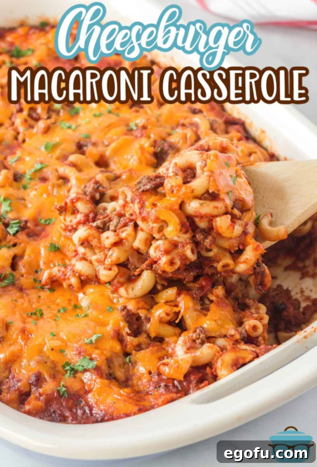 Pinterest image showing a serving spoon scooping out a generous portion of the cheesy Cheeseburger Macaroni Casserole, highlighting its rich texture and melty cheese.