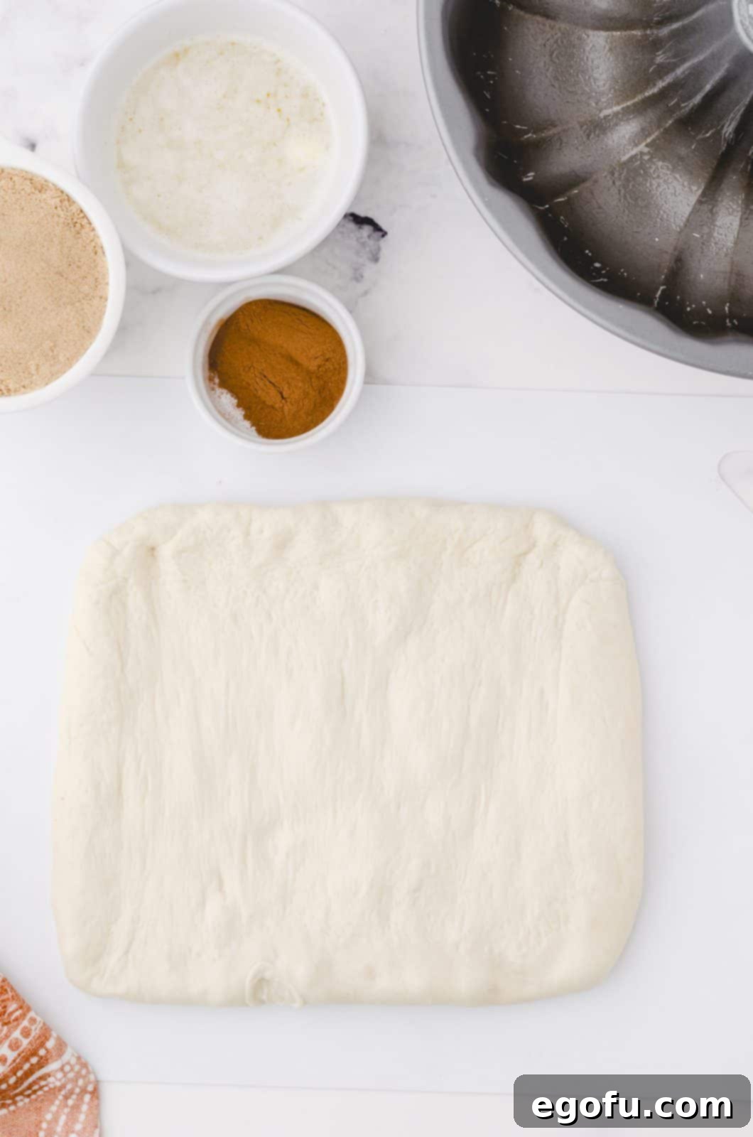 Thawed bread dough patted into a square.