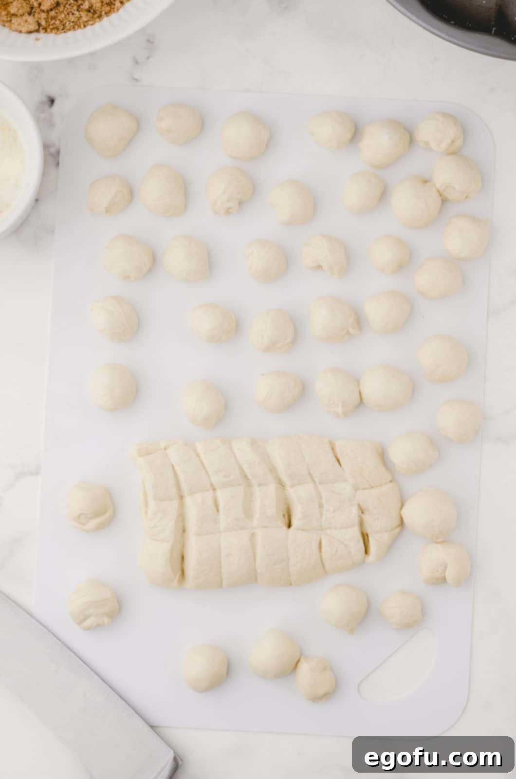 Bread dough being cut and rolled into balls.