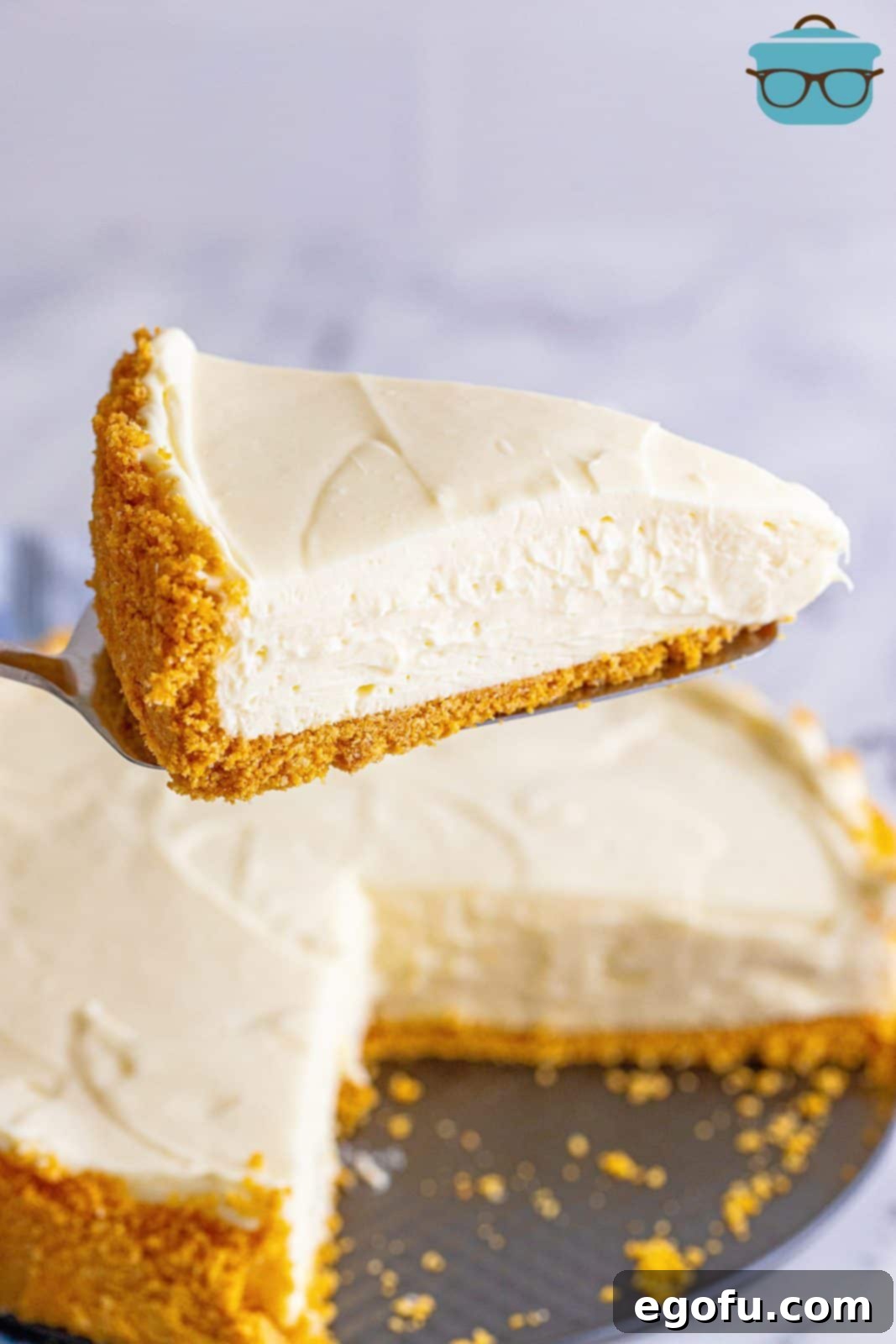 Pie server holding up finished slice of No-Bake Cheesecake.