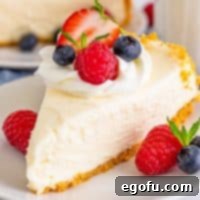 Close up square image of No-Bake Cheesecake topped with whipped cream and fruit.
