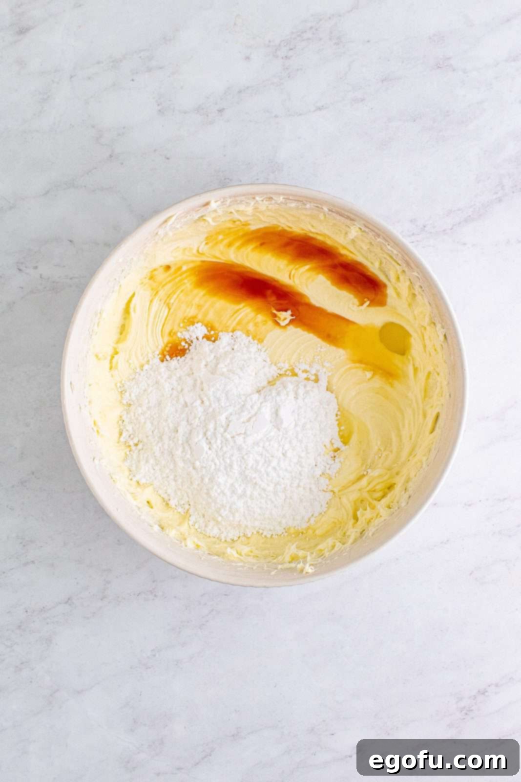 Powdered sugar, vanilla, and lemon juice added to cream cheese and sugar mixture.