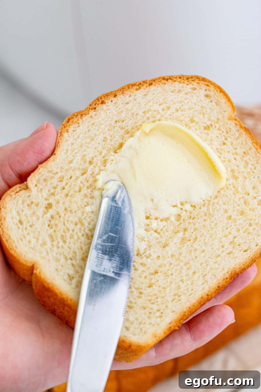 Air Fryer's Golden Crispy Grilled Cheese 5 Butter being put on one slice of bread.
