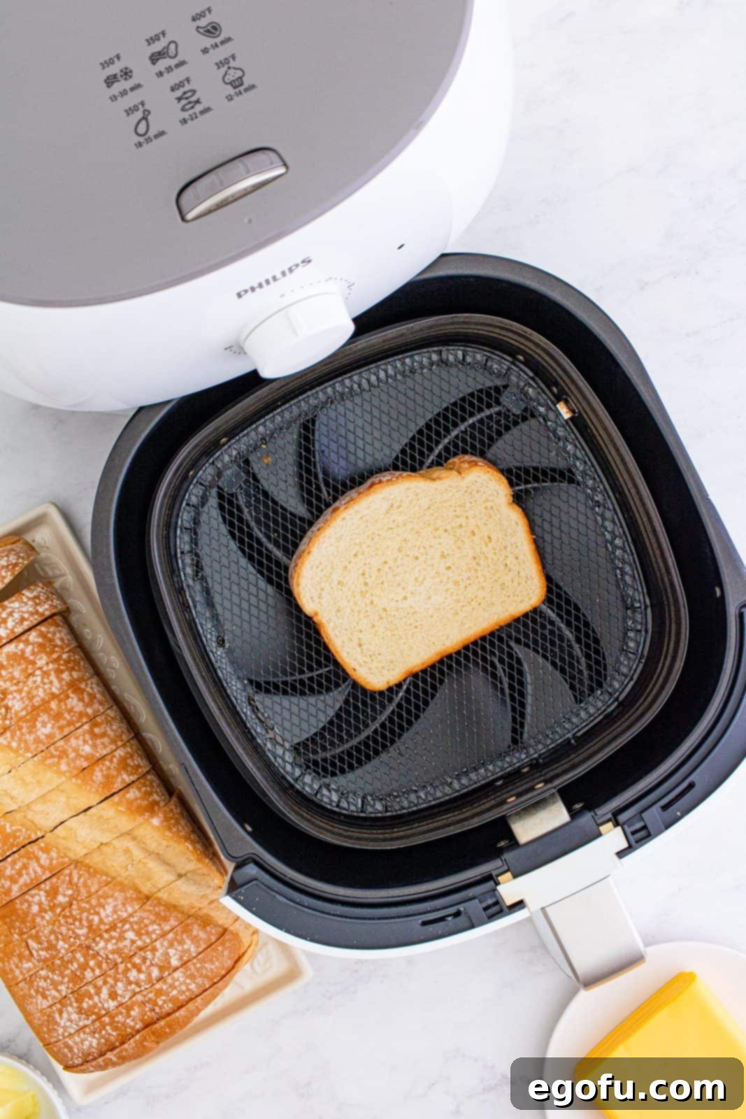 Air Fryer's Golden Crispy Grilled Cheese 6 Buttered bread placed buttered side down in air fryer basket.