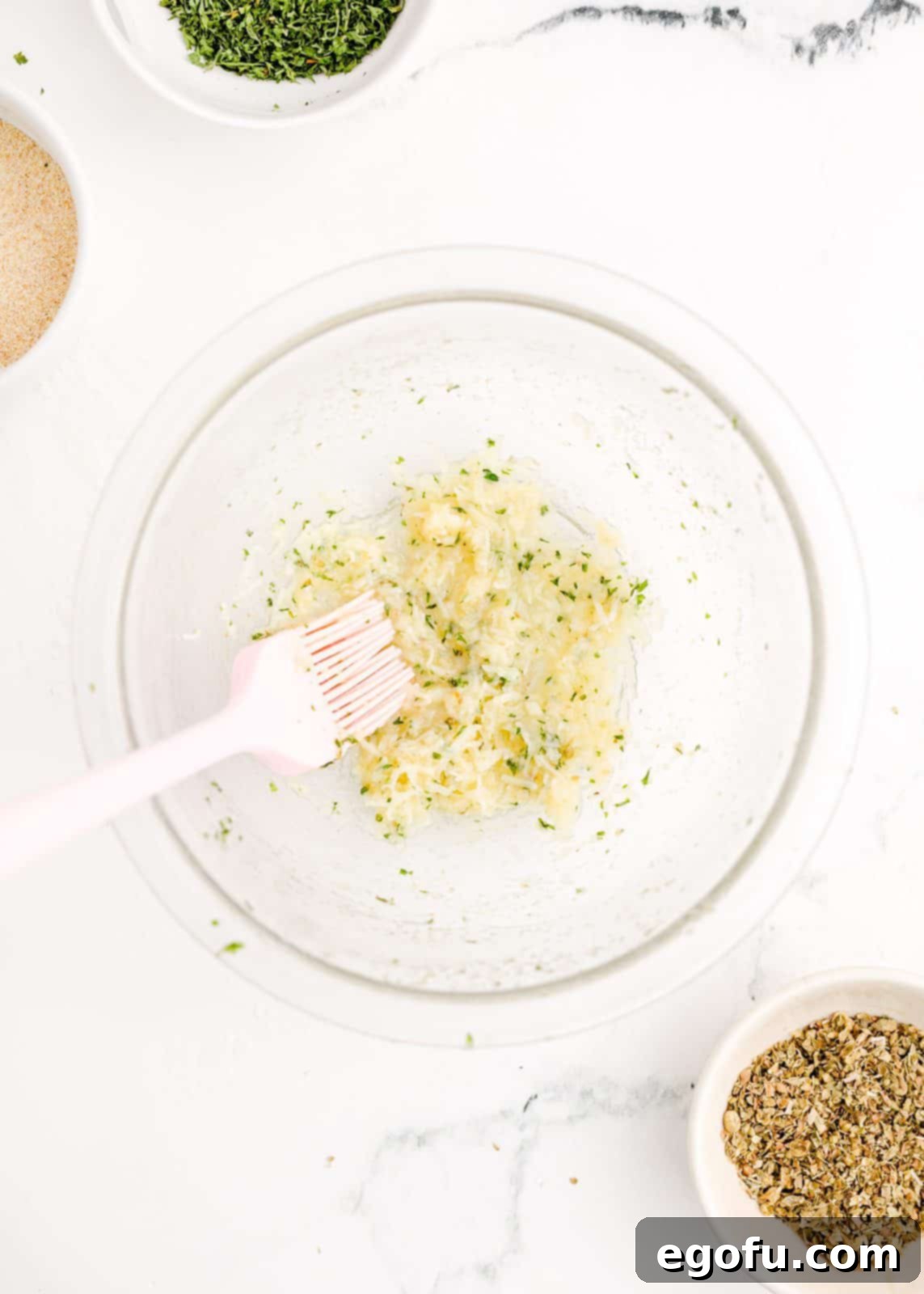 Parmesan cheese stirred into the remaining garlic butter mixture in a bowl.