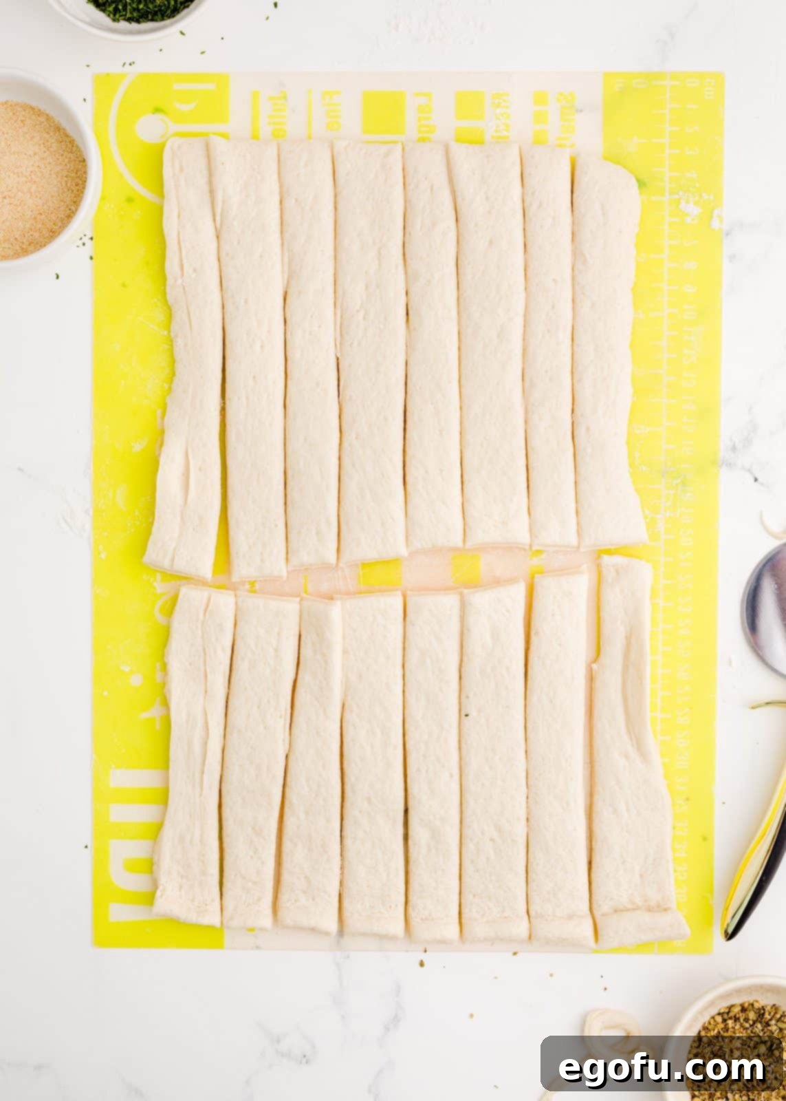 Pizza dough further cut into 16 strips, forming individual pieces for knots.