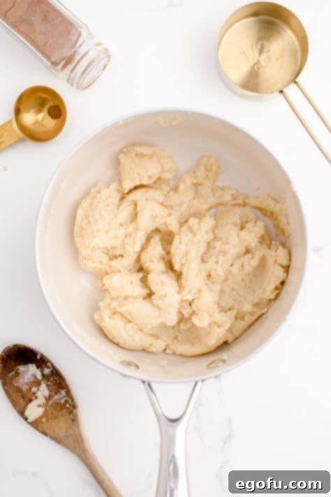 Flour added to pan with water and butter mixture mixed into a play-do like mixture.