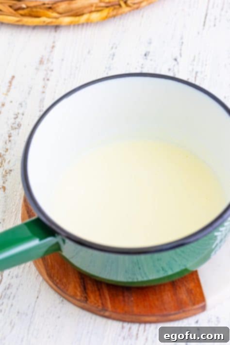 A pot of heated heavy cream, gently bubbling on the stovetop.