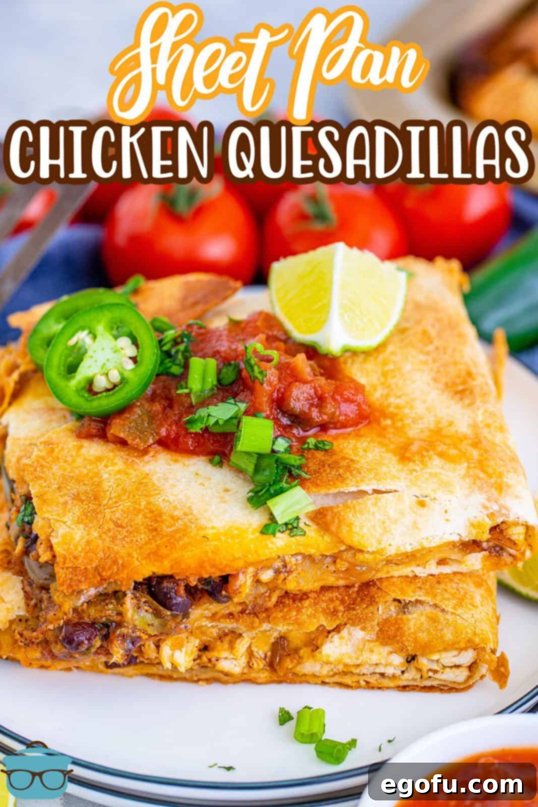 Stacked Sheet Pan Chicken Quesadillas on a white plate, garnished with fresh cilantro and a lime wedge, ready for serving.