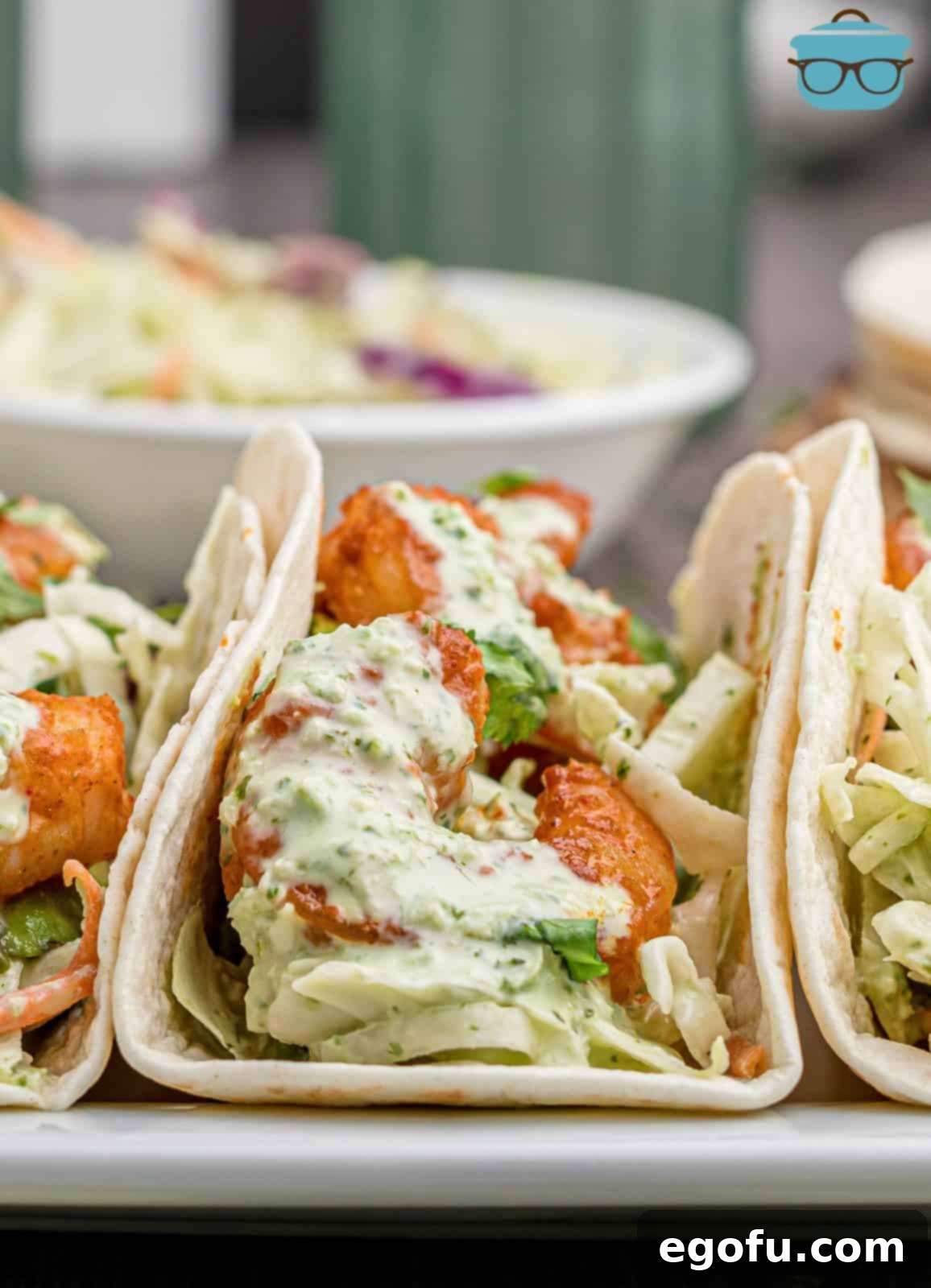 Close up of straight on photo of Shrimp Tacos in tortillas with slaw.