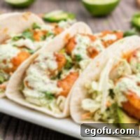 Close up square image of Shrimp Tacos on white platter showing shrimp and slaw.