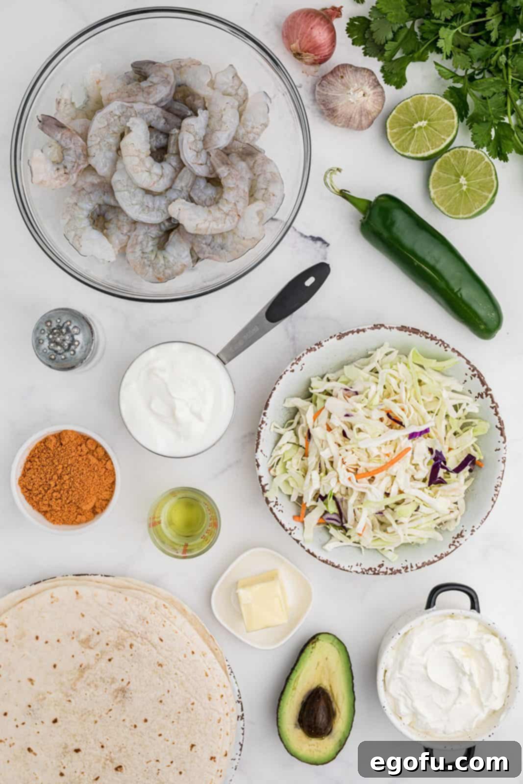 Ingredients needed: salted butter, taco seasoning, large shrimp, flour tortillas, greek yogurt (or sour cream), olive  oil, garlic, shallot, jalapeño, cilantro, salt, lime zest and coleslaw mix.