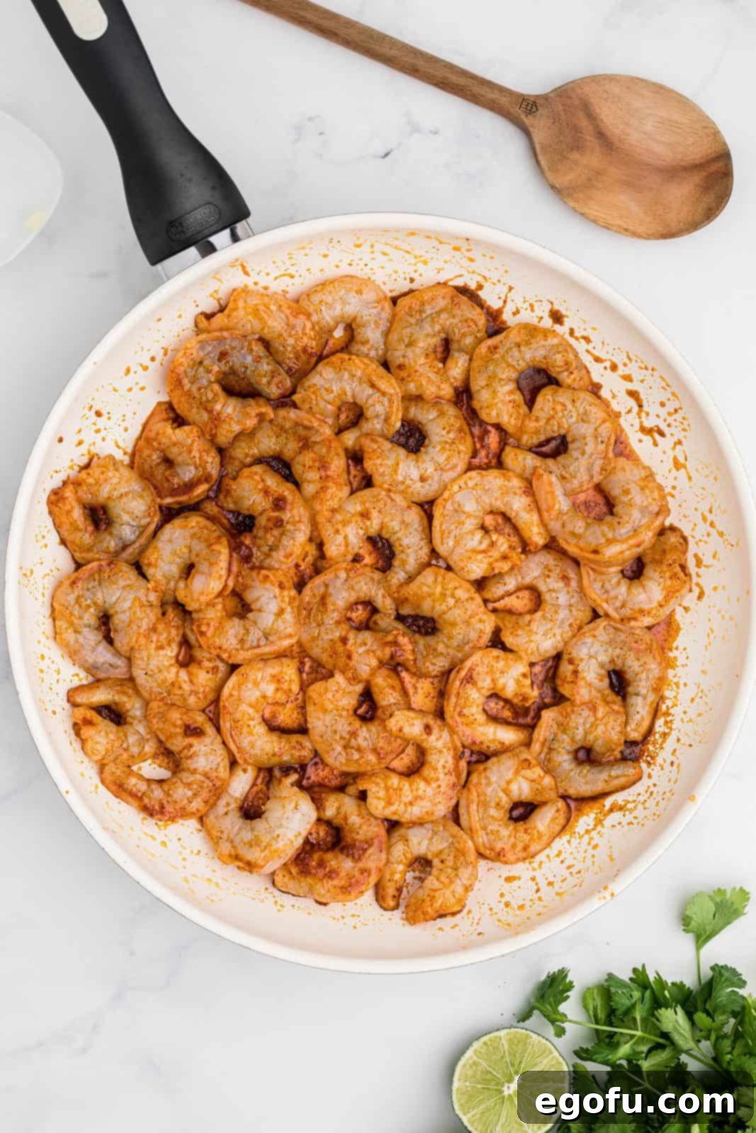 Coated shrimp added to pan.