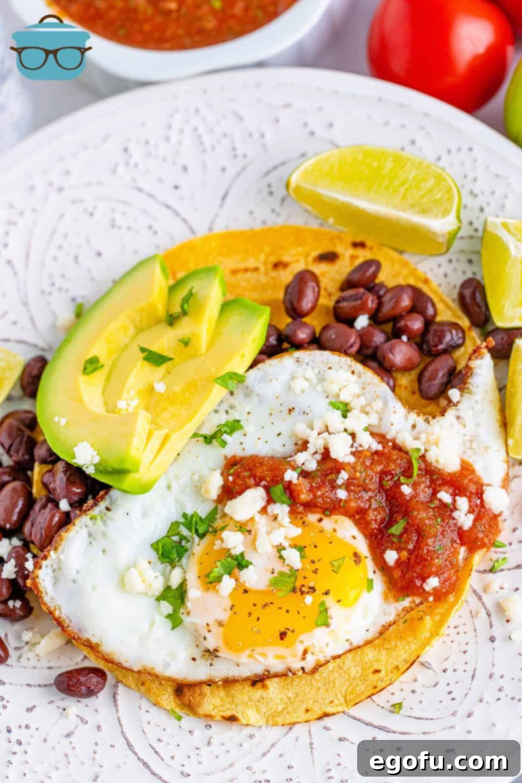 Zesty Ranch Morning Stack 2 Overhead of Huevos Rancheros on plate with garnishes and lime slices, showcasing a beautiful, freshly prepared Mexican breakfast.