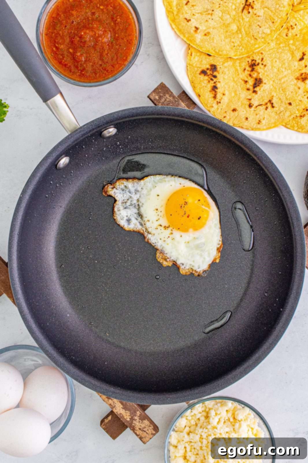 Zesty Ranch Morning Stack 5 A single egg frying perfectly in a nonstick pan, with a golden yolk and crispy edges.