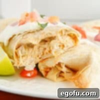 Square image of finished Air Fryer Chicken Chimichangas topped and split and half.