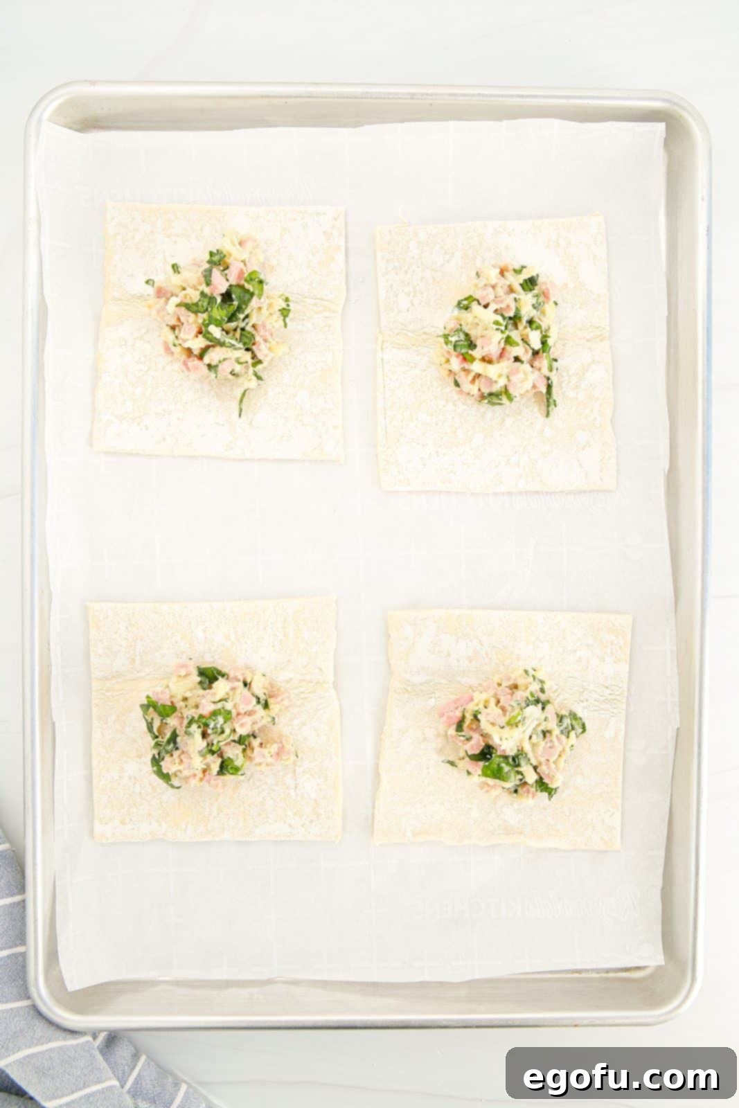 Filling mixture carefully added to the center of each puff pastry square.