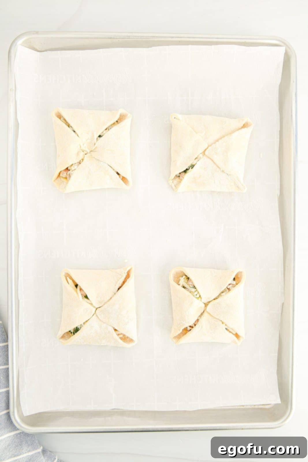 Puff pastry corners expertly folded over the filling to create a sealed pocket.