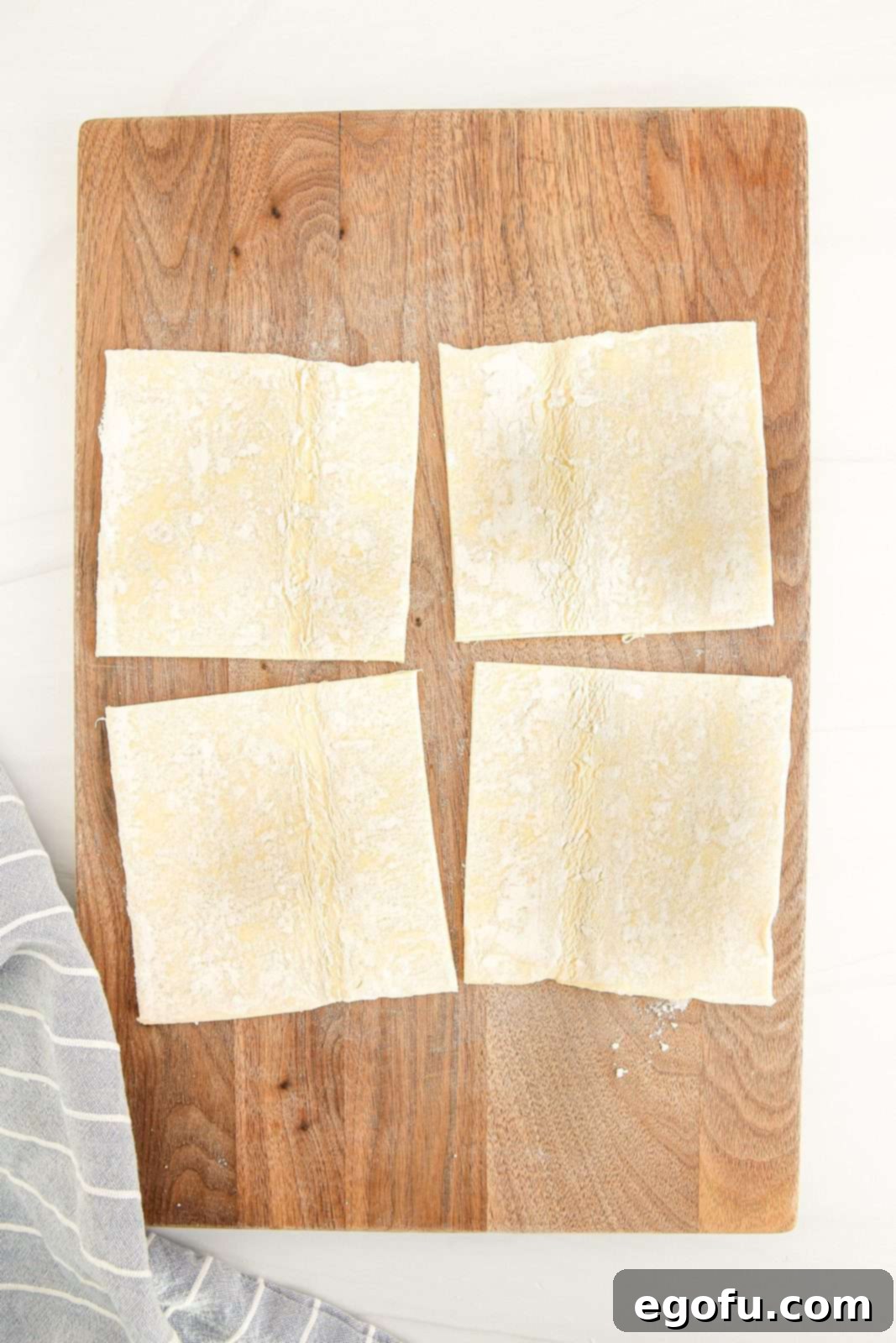 Puff pastry sheet precisely cut into perfect squares.