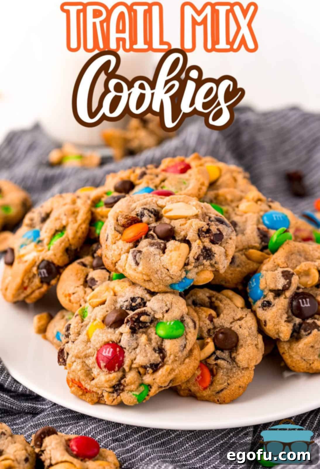 Trail mix cookies on white plate showing ingredients Pinterest image.