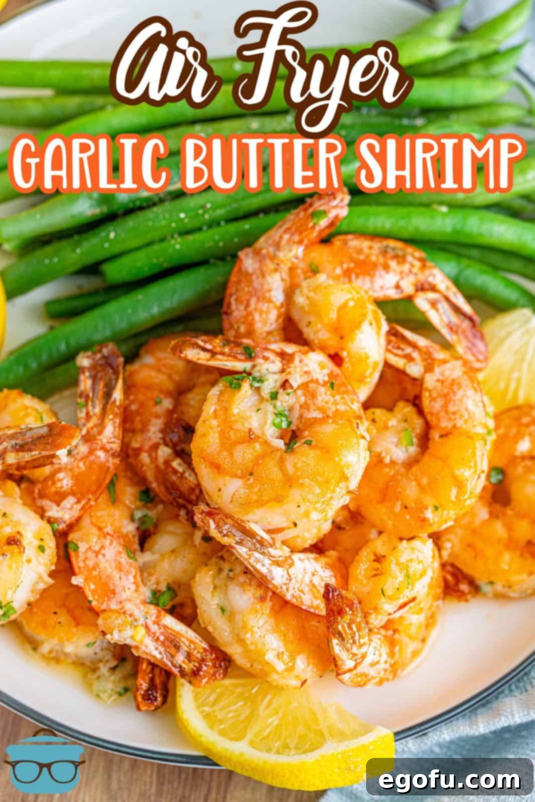 A beautifully styled plate of Air Fryer Garlic Butter Shrimp, garnished with fresh green beans and vibrant lemon slices, perfect for a Pinterest share.