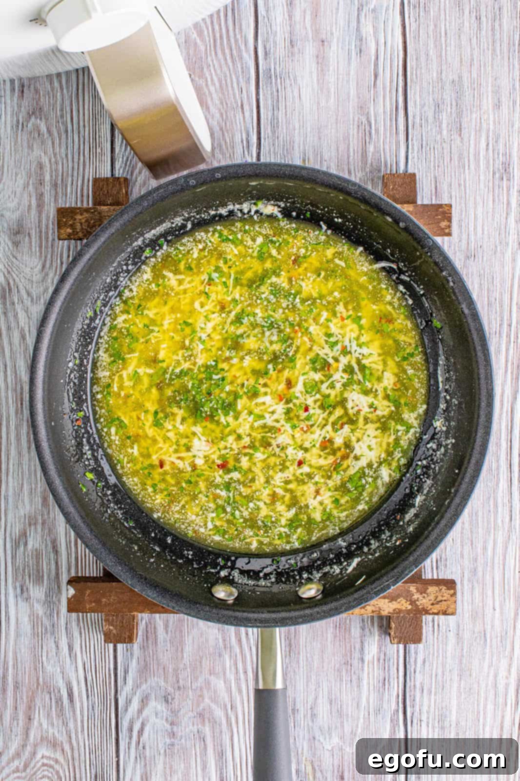 Melted butter infused with lemon juice, garlic powder, kosher salt, red pepper flakes, and fresh parsley, thoroughly whisked into a savory sauce.