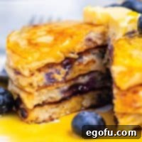 Square image of stacked Blueberry Pancakes with triangle cut removed.