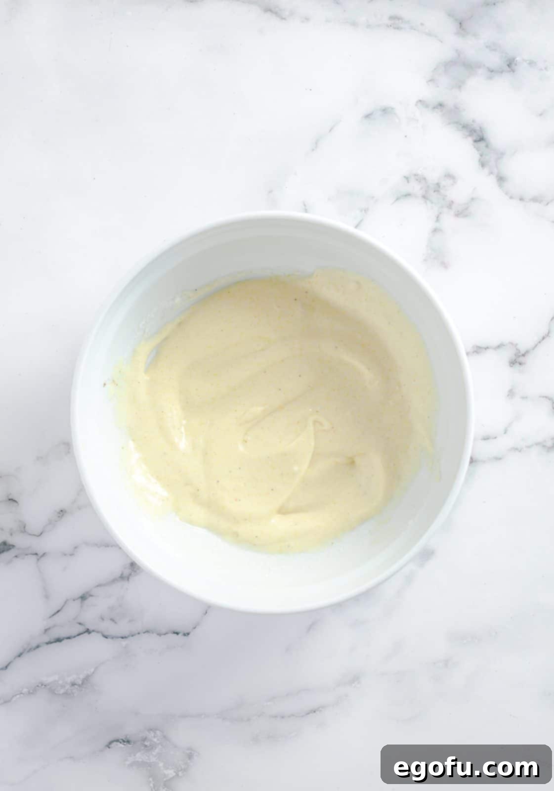 All dressing ingredients perfectly mixed together in a bowl, creating a creamy base for the chicken salad.