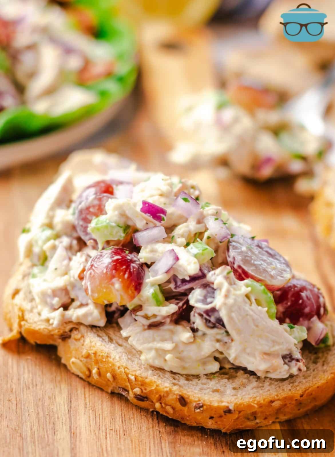 A close-up view of the finished Grape Chicken Salad, elegantly served on a slice of bread, revealing all the delightful ingredients.