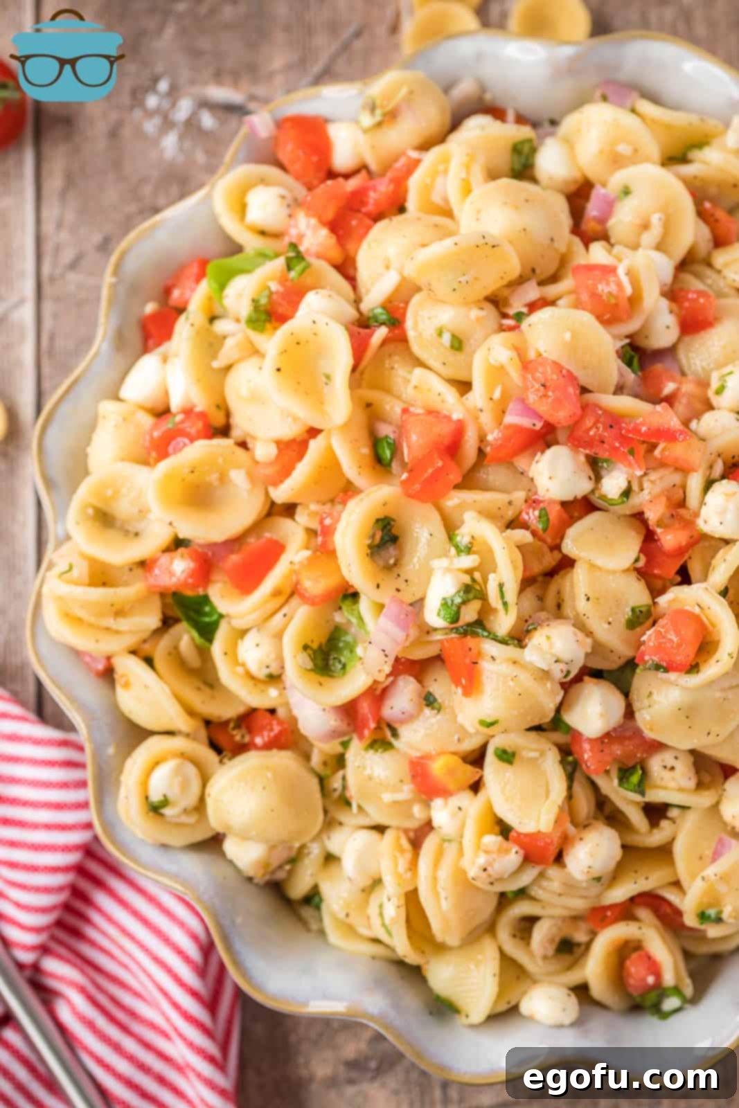 Overhead photo of Bruschetta Pasta Salad in serving bowl, showcasing fresh tomatoes, basil, and mozzarella.