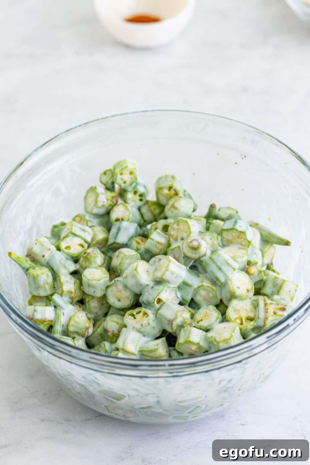 Soulful Crispy Okra 6 Buttermilk, garlic salt, and pepper added to okra and stirred.