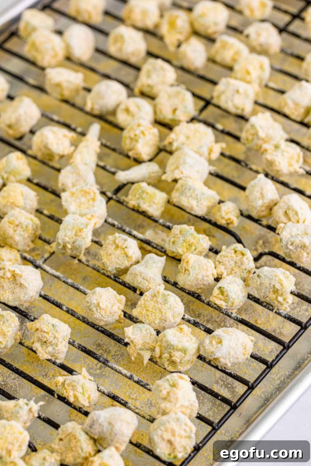 Soulful Crispy Okra 10 Tossed okra in cornmeal and flour mixture placed on a wired rack.