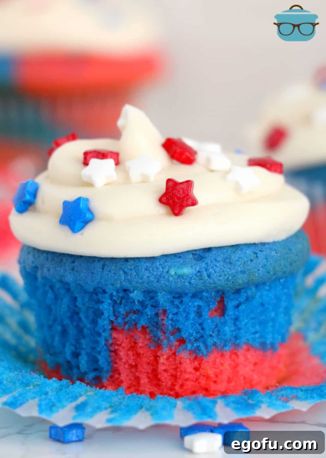 Red, White and Blue Cupcakes with paper liner pulled down and frosted with star sprinkles.