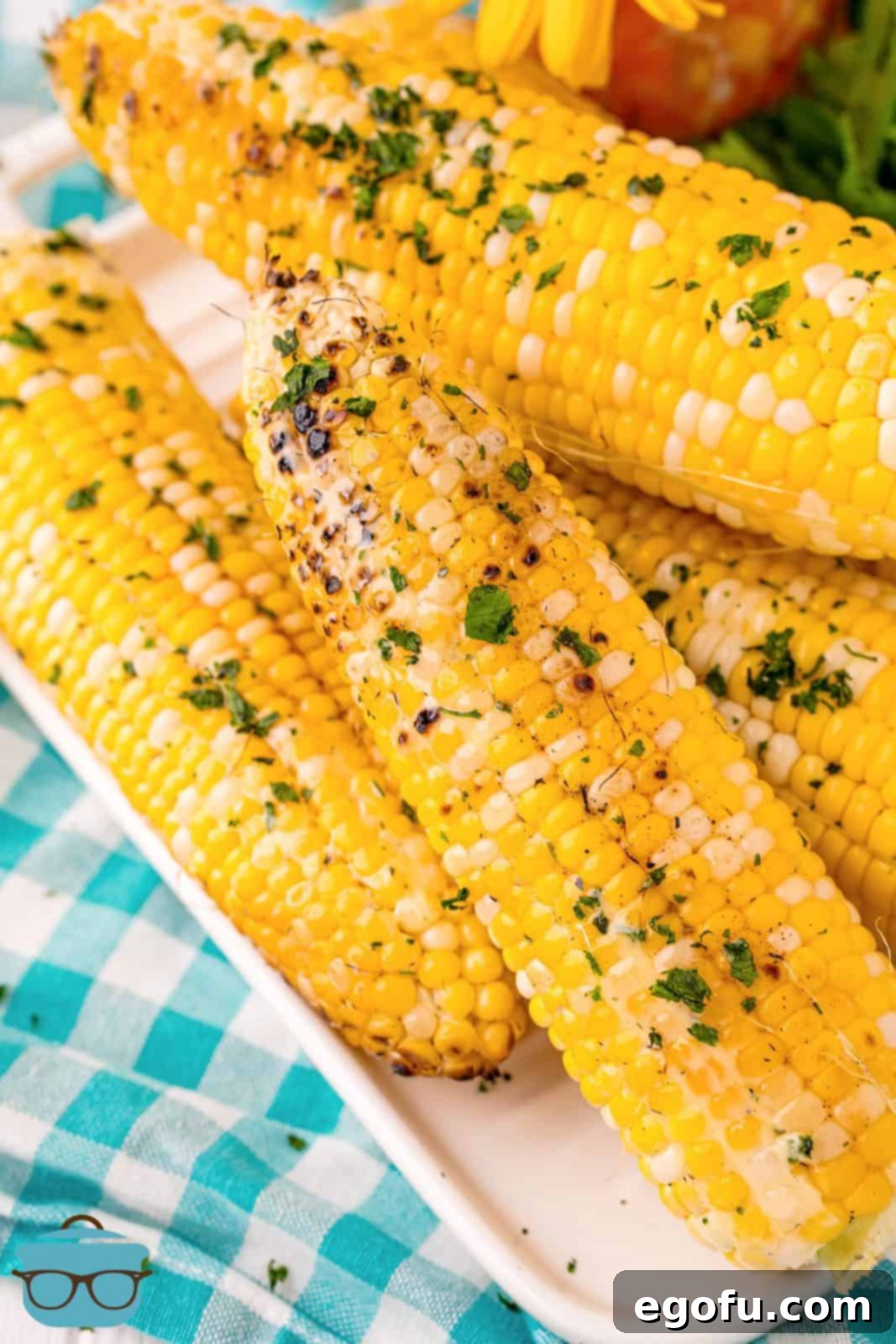 Overhead of Grilled Corn showing butter and herbs.