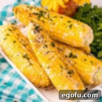 Square image of stacked Grilled Corn on white platter.