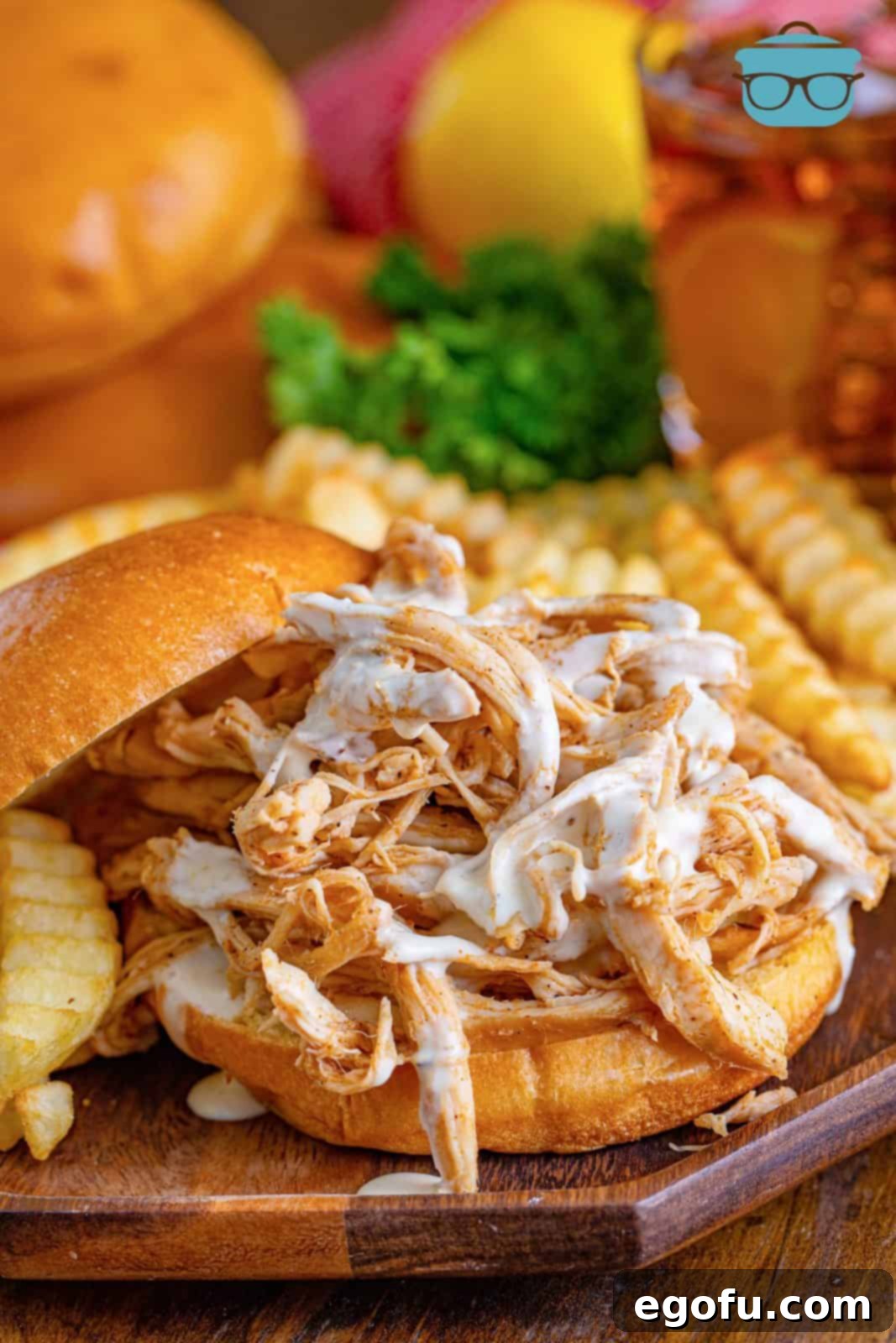 The South's Signature White BBQ 7 Alabama White Sauce drizzled over bbq chicken sandwich.