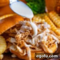 The South's Signature White BBQ 8 Square image of sauce being drizzle over sandwich.