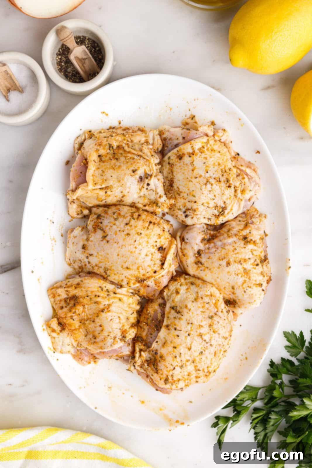 Crispy Lemon Pepper Air Fryer Chicken Thighs 12 Seasoned chicken thighs resting on a platter.