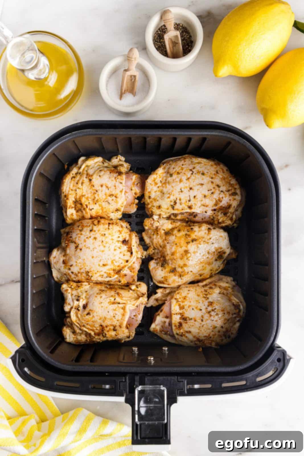 Crispy Lemon Pepper Air Fryer Chicken Thighs 13 Seasoned chicken thighs carefully placed in a single layer in an air fryer basket, ready for cooking.