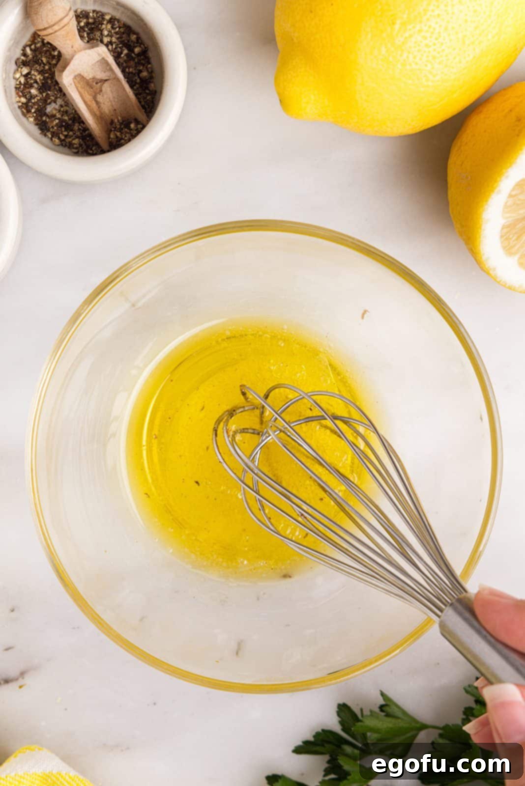 Crispy Lemon Pepper Air Fryer Chicken Thighs 7 A small bowl with olive oil and lemon juice being whisked together.
