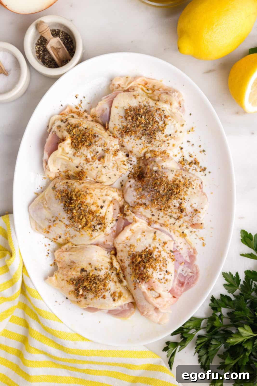 Crispy Lemon Pepper Air Fryer Chicken Thighs 10 The dry spice mixture being poured over the seasoned chicken thighs.