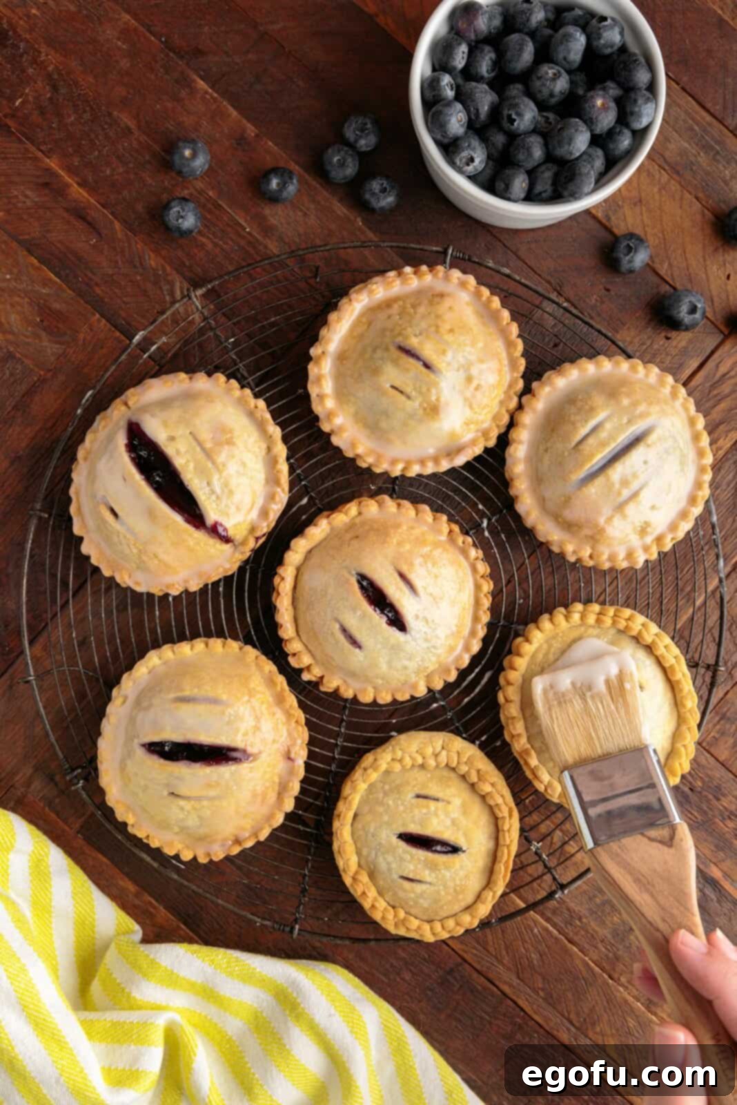 Glaze being brushed over hand pies.