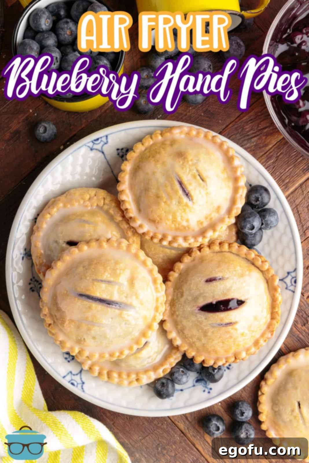 Pinterest image of stacked glazed Air Fryer Blueberry Hand Pies on plate with blueberries surrounding them.