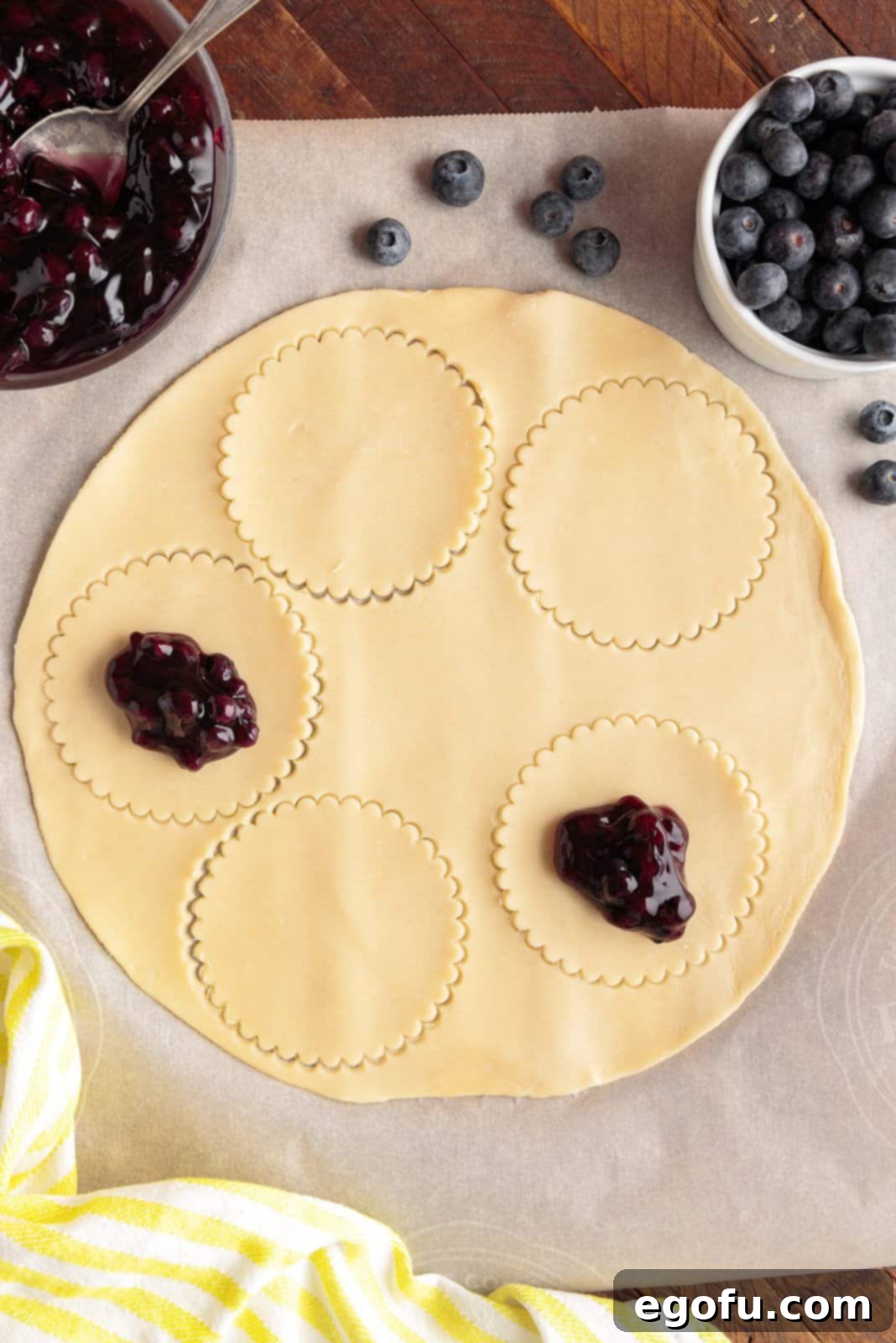 Pie filling being added to cut circles.