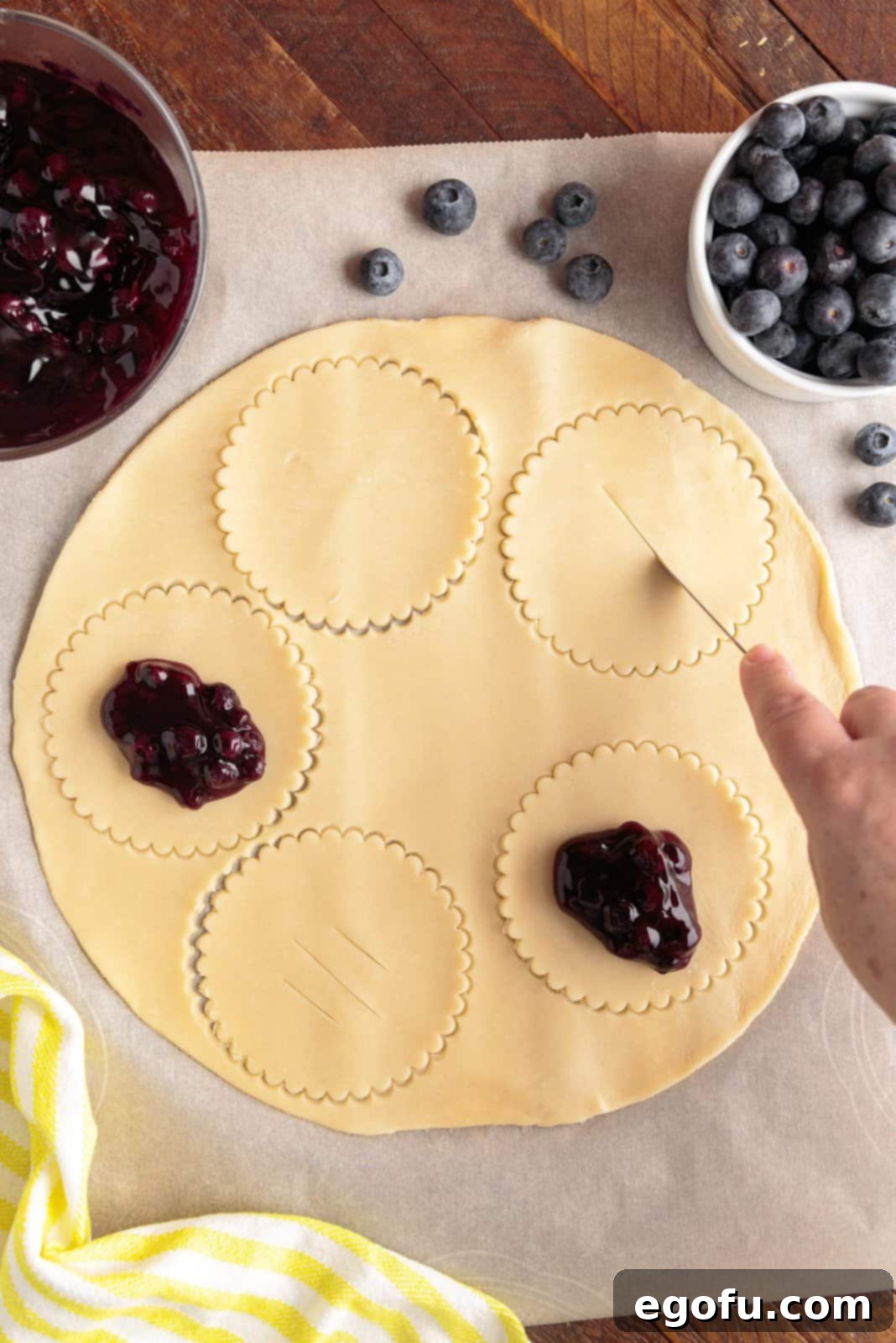 Slits being cut in what will be the tops of the pies.