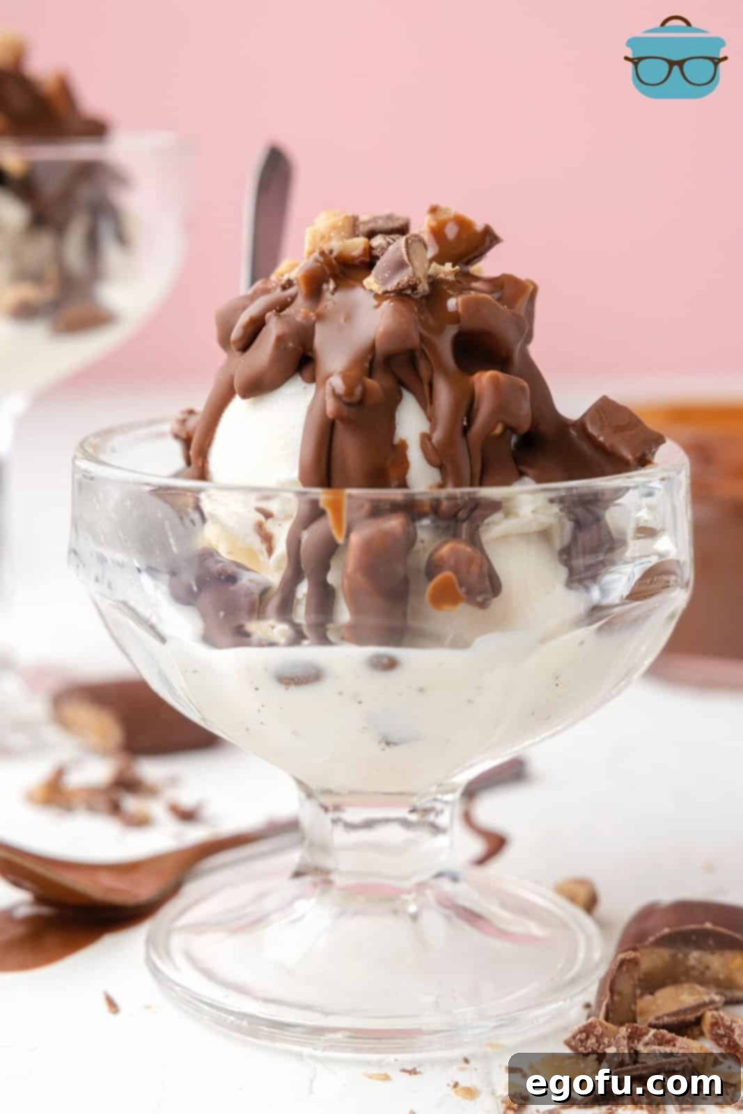 Heath Bar Magic Shell generously poured over a serving of ice cream in a clear parfait cup, clearly showcasing the firm, delicious topping with visible toffee bits.
