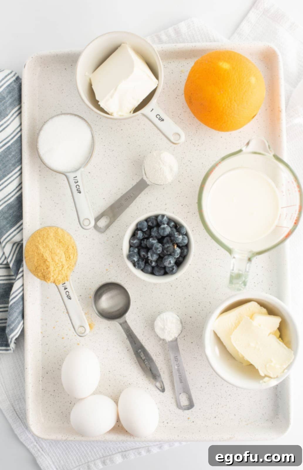 Ingredients needed: graham cracker crumbs, salted butter, cream cheese, granulated sugar, eggs, all-purpose flour, orange zest, heavy cream, salt, blueberries, orange juice or lemon juice, water and cornstarch.