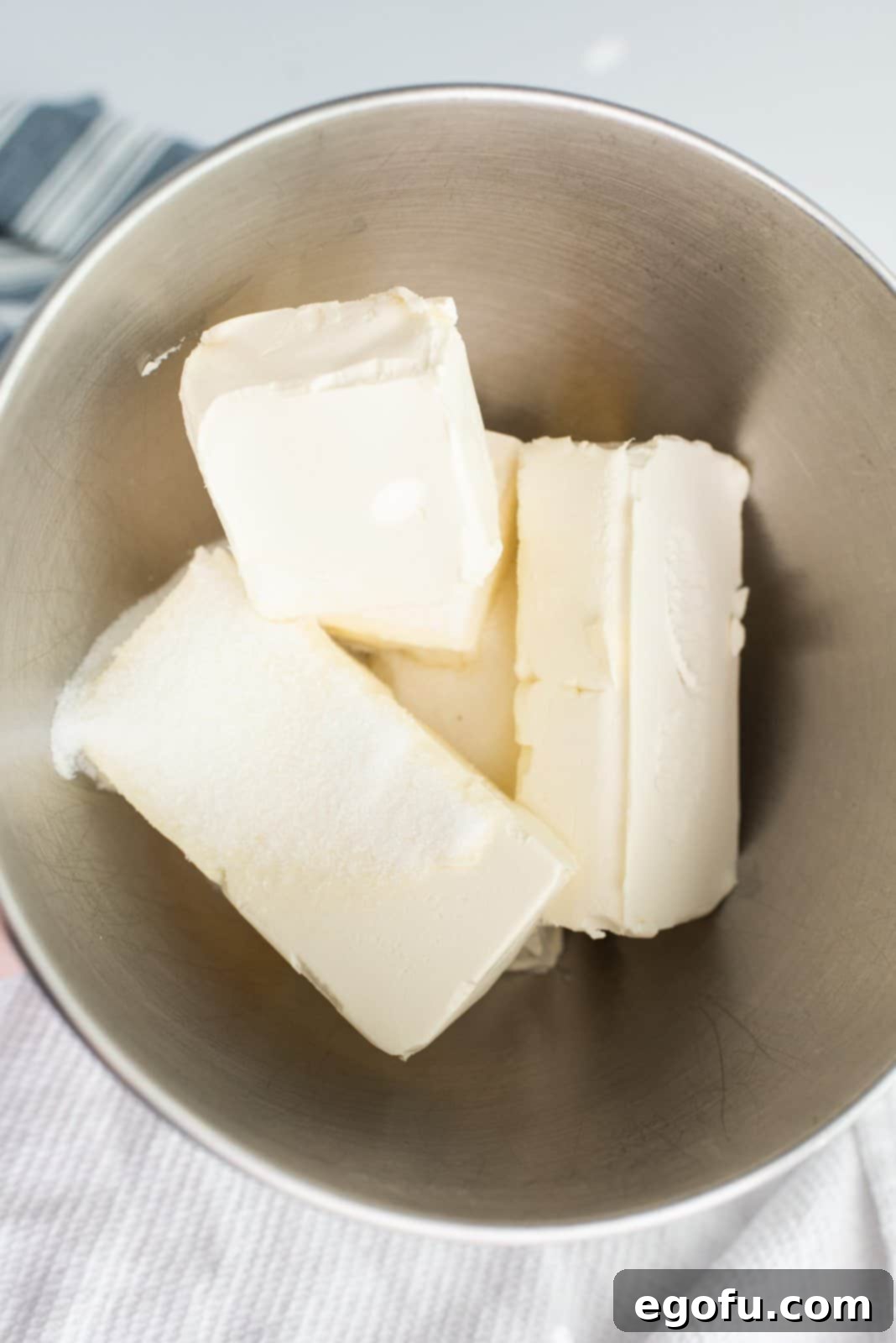 Cream cheese and sugar added to bowl of stand mixer.