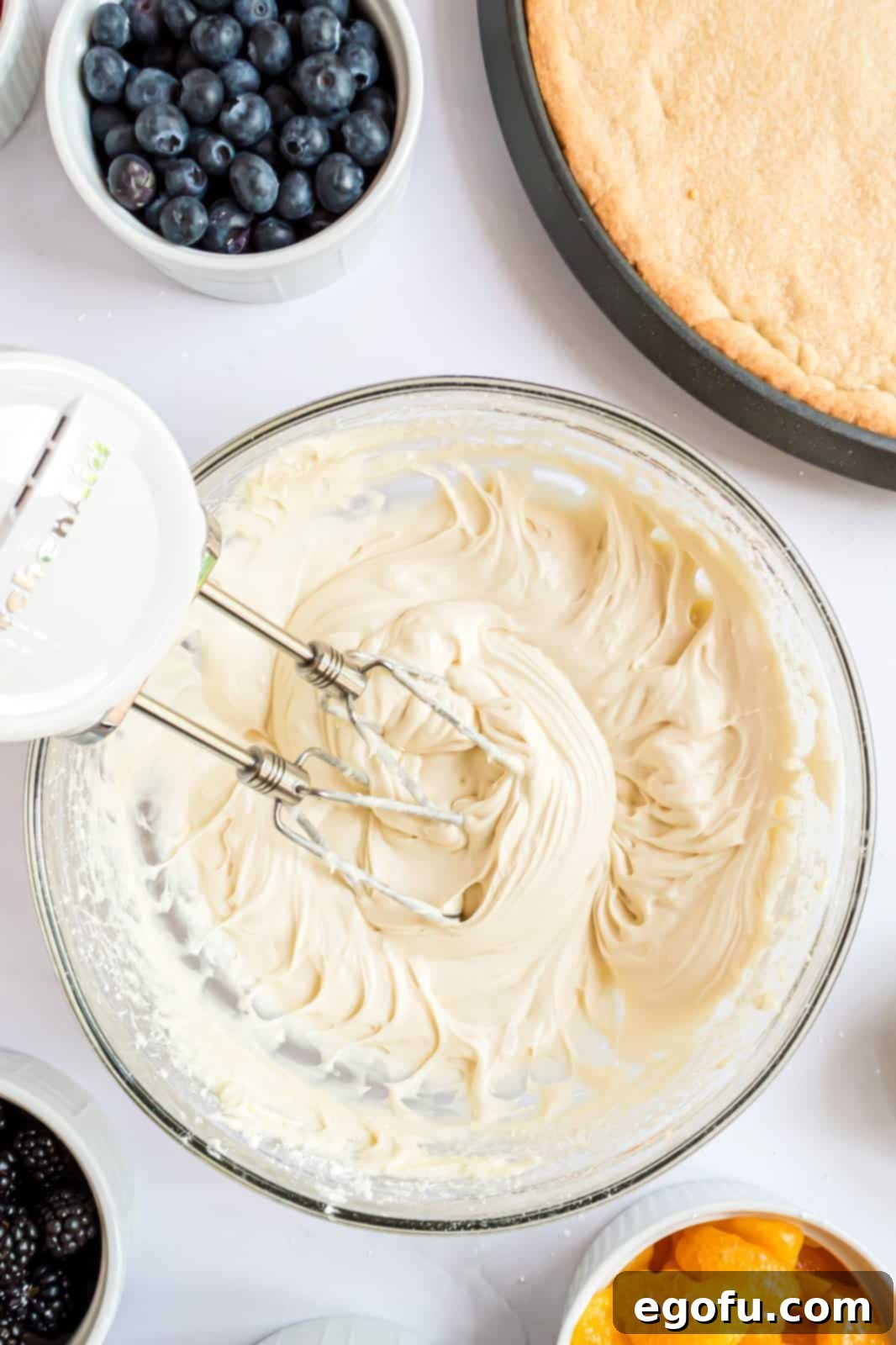 Powdered sugar and vanilla beaten into cream cheese mixture in bowl.